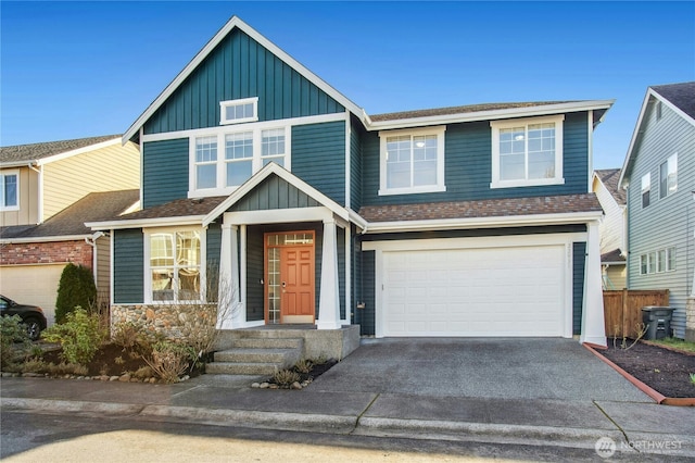 view of front of property featuring a garage, driveway, board and batten siding, and roof with shingles