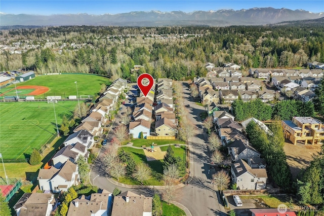 bird's eye view featuring a residential view, a mountain view, and a wooded view