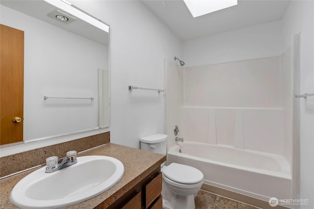 full bath featuring toilet, a skylight, vanity, and bathing tub / shower combination