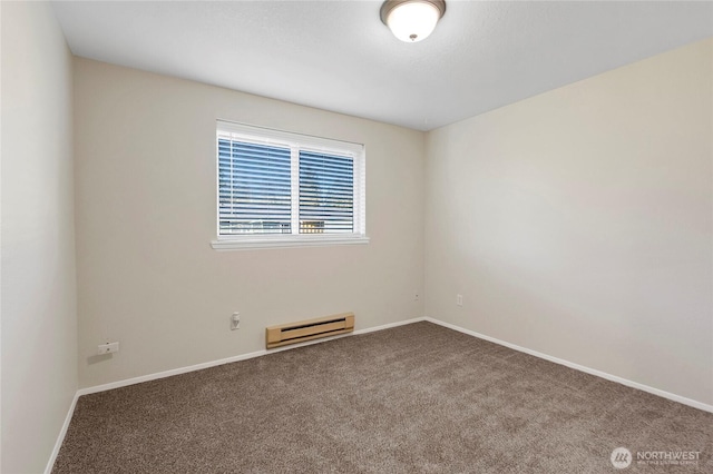 spare room featuring carpet, a baseboard heating unit, and baseboards