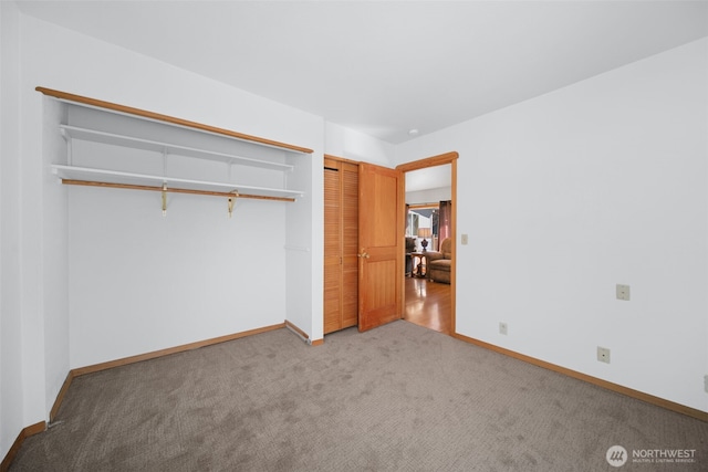 unfurnished bedroom featuring carpet, baseboards, and a closet