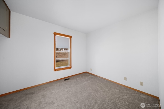 unfurnished room featuring baseboards, visible vents, and carpet flooring