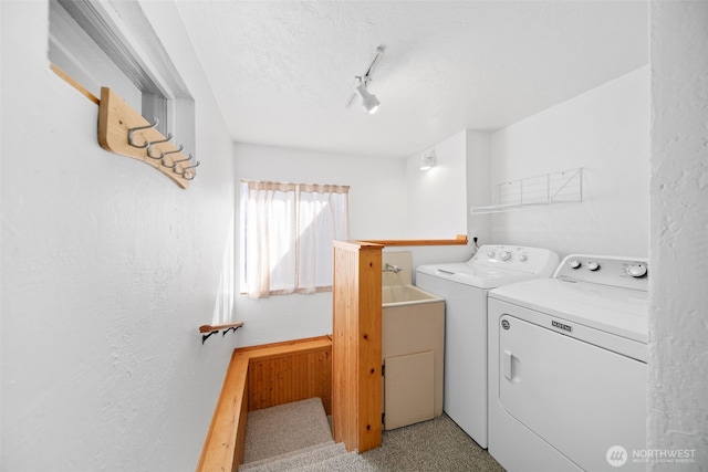 laundry room featuring washing machine and dryer, rail lighting, a textured wall, and a textured ceiling