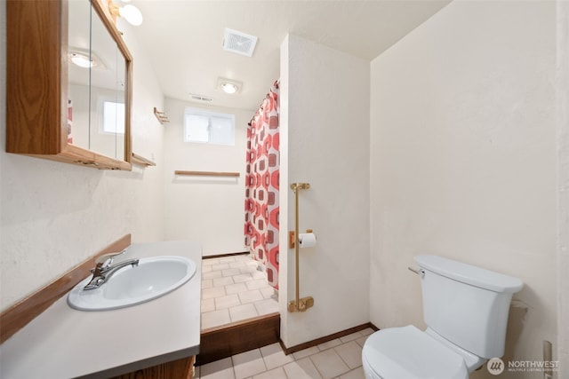 bathroom with visible vents, vanity, toilet, and tile patterned floors