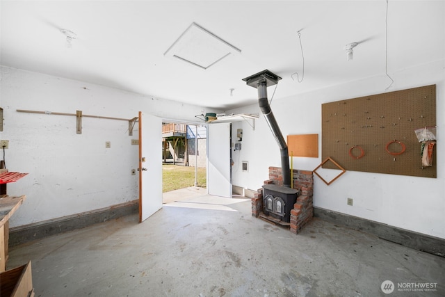 garage featuring a wood stove and baseboards