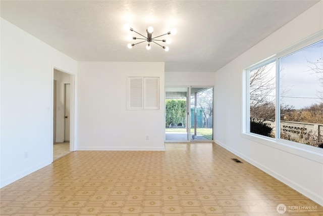 unfurnished room featuring visible vents, light floors, baseboards, and an inviting chandelier