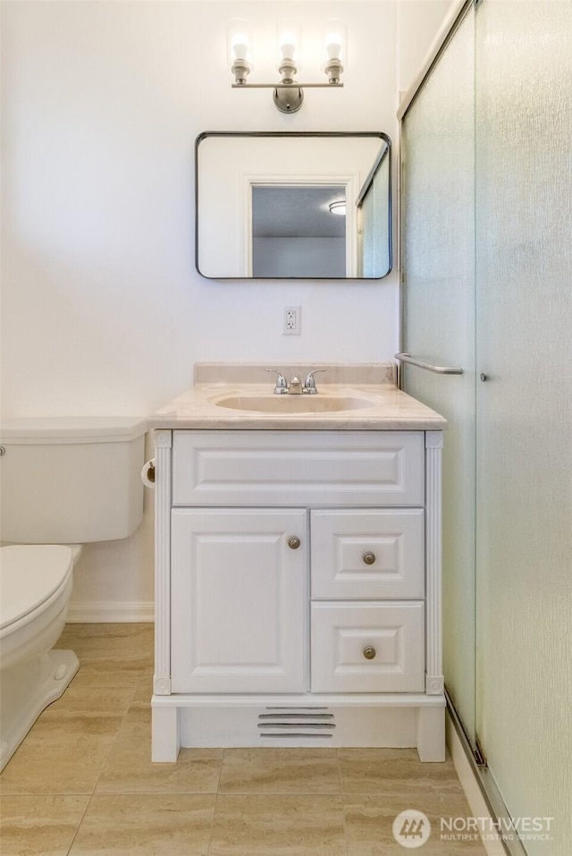 bathroom with vanity, toilet, and baseboards