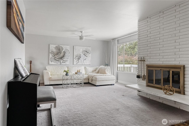 carpeted living room with a ceiling fan, a brick fireplace, and baseboards