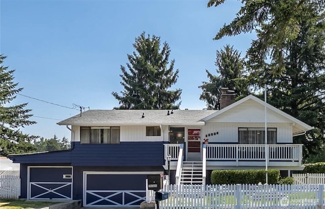 view of front of home with a garage, stairway, a chimney, and fence