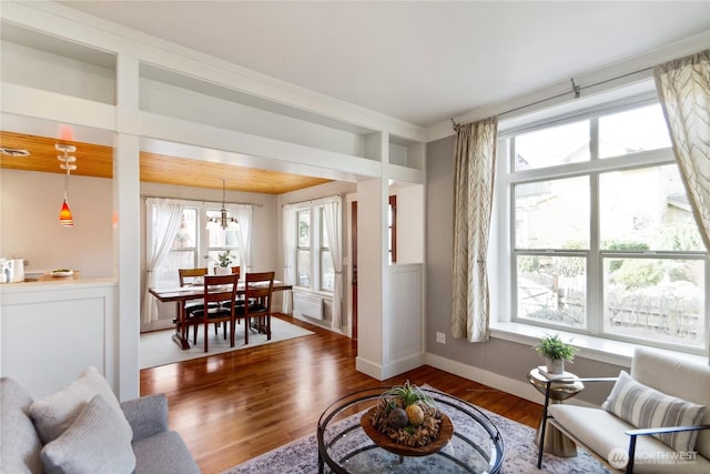 living area with a notable chandelier, wood finished floors, and baseboards