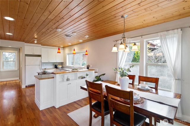 dining area featuring recessed lighting, a healthy amount of sunlight, wood finished floors, and wooden ceiling