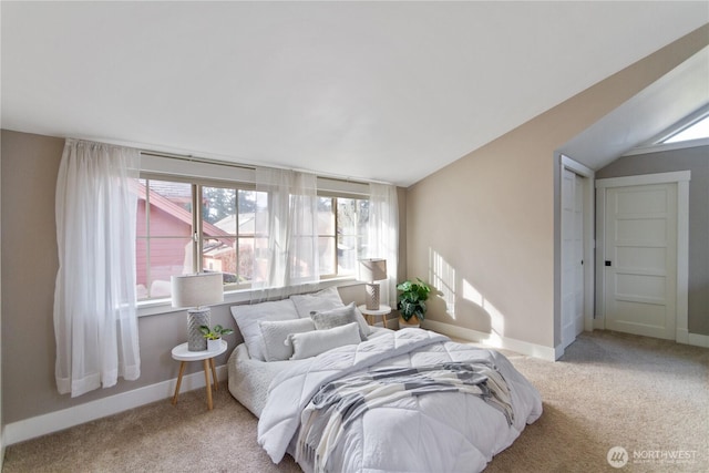 carpeted bedroom with lofted ceiling and baseboards