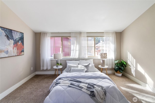 carpeted bedroom featuring vaulted ceiling and baseboards