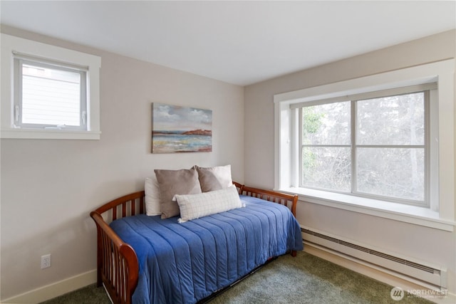 carpeted bedroom featuring a baseboard heating unit and baseboards