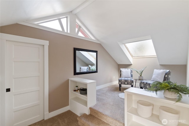 interior space featuring baseboards, vaulted ceiling with skylight, and carpet