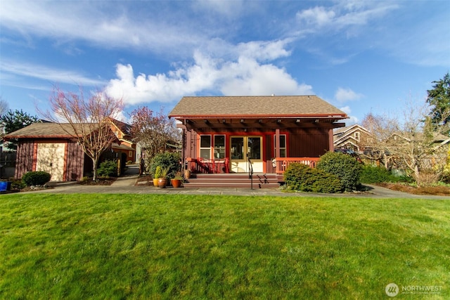 back of property with covered porch and a yard