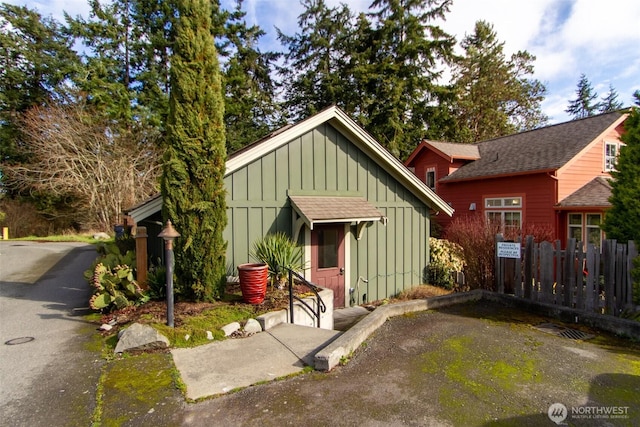 view of front facade featuring board and batten siding and fence