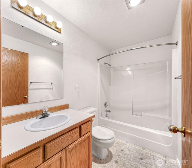 full bathroom with tub / shower combination, toilet, vanity, and a textured ceiling