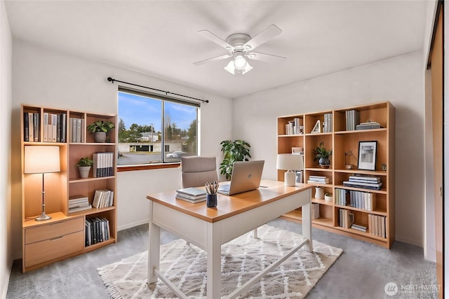 home office with carpet, a ceiling fan, and baseboards