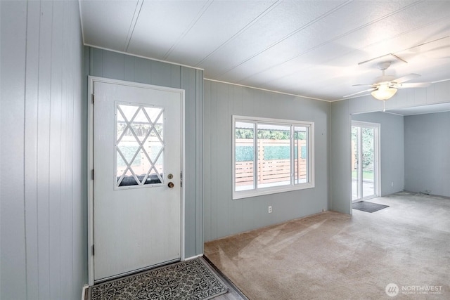 carpeted foyer entrance featuring a ceiling fan