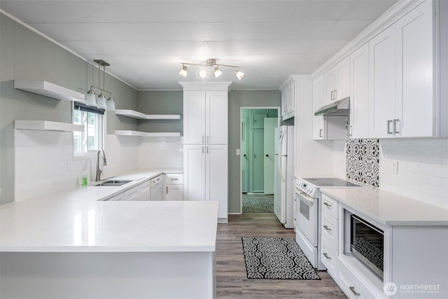 kitchen featuring white appliances, open shelves, a peninsula, a sink, and under cabinet range hood