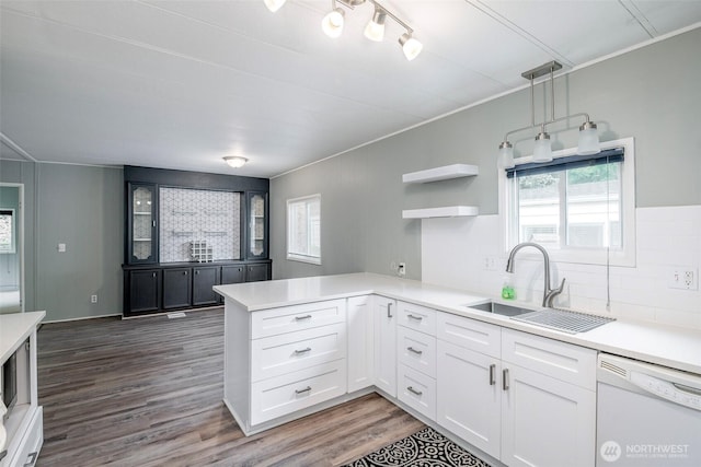 kitchen featuring a wealth of natural light, a sink, a peninsula, and white dishwasher