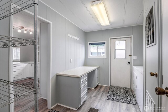 interior space with laundry area, visible vents, and light wood-type flooring