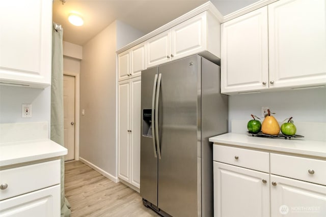 kitchen with white cabinetry, light countertops, and stainless steel refrigerator with ice dispenser