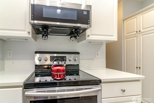 kitchen with white cabinets, stainless steel appliances, and light countertops