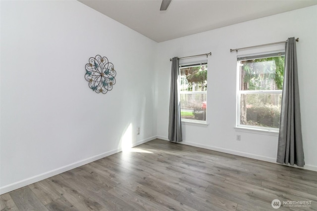 unfurnished room featuring a ceiling fan, wood finished floors, and baseboards