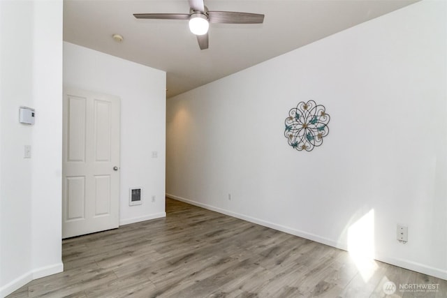 unfurnished room featuring visible vents, wood finished floors, baseboards, and ceiling fan