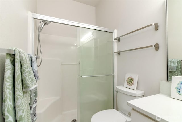 bathroom with vanity, toilet, and a shower stall