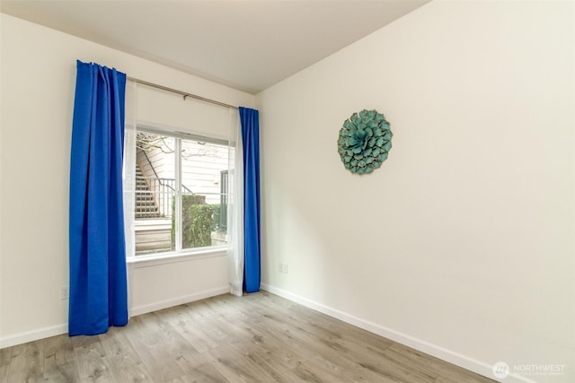 spare room with wood finished floors and baseboards