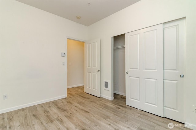 unfurnished bedroom with visible vents, baseboards, a closet, and light wood finished floors