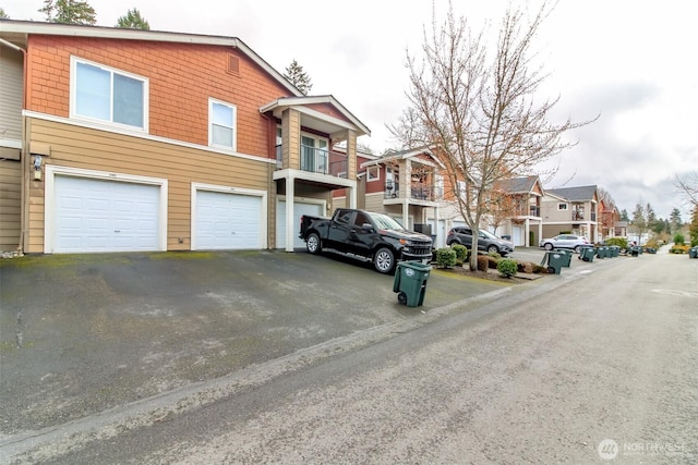 exterior space featuring a garage, a residential view, and driveway