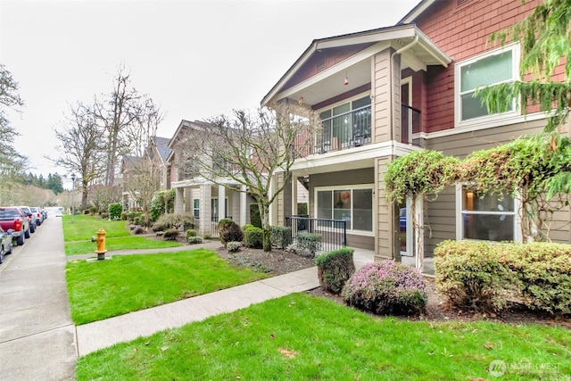 exterior space featuring a lawn and a balcony