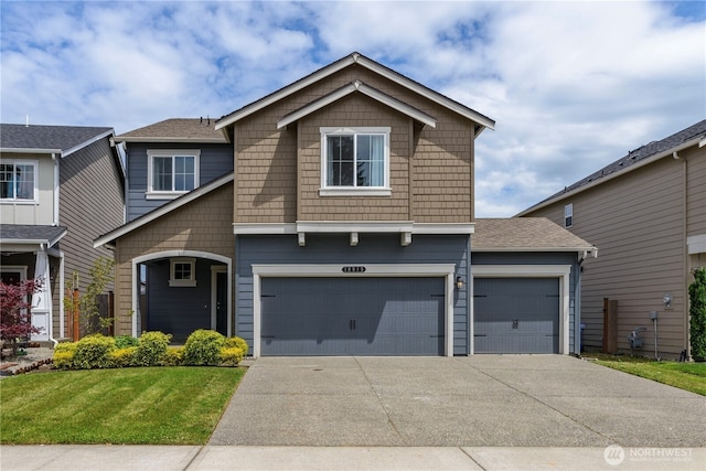 view of front facade featuring a garage, driveway, and a front yard