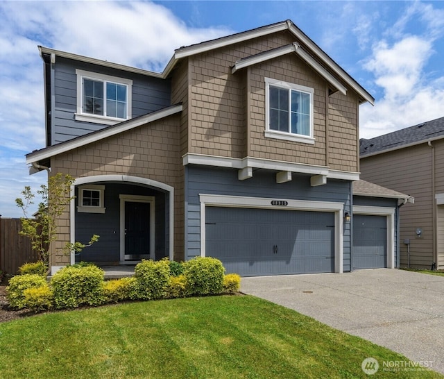 view of front of home featuring an attached garage, driveway, fence, and a front lawn