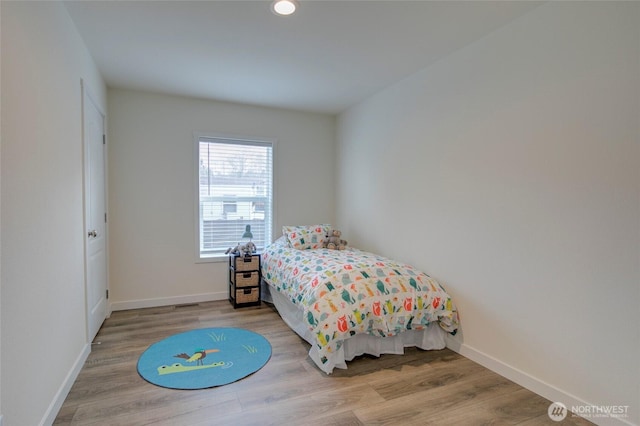 bedroom with baseboards and wood finished floors