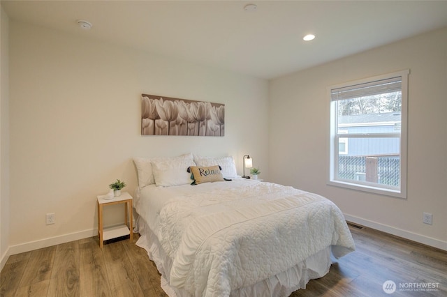 bedroom featuring visible vents, baseboards, wood finished floors, and recessed lighting