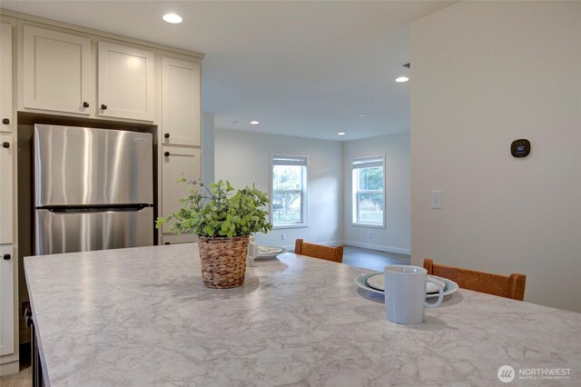 kitchen with freestanding refrigerator, white cabinets, baseboards, and recessed lighting