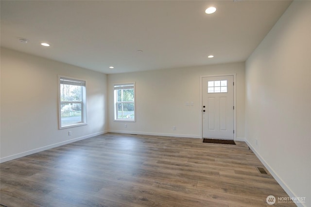 foyer entrance with baseboards, wood finished floors, and recessed lighting