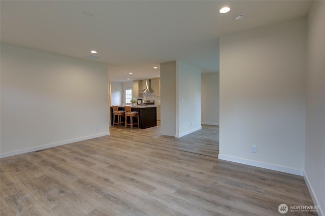 unfurnished living room featuring baseboards, light wood-style flooring, and recessed lighting