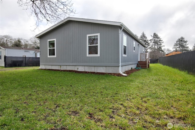 view of side of property with a yard and fence