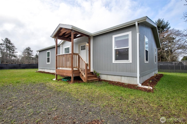 manufactured / mobile home with fence and a front lawn