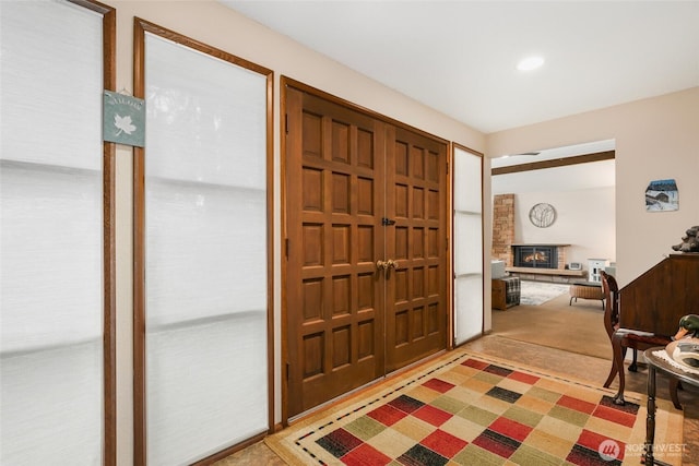 carpeted entrance foyer with recessed lighting and a brick fireplace