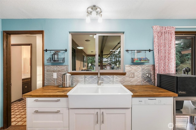 bathroom with a textured ceiling, decorative backsplash, vanity, and tile patterned floors