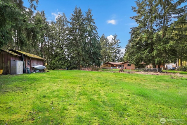 view of yard featuring an outdoor structure and fence