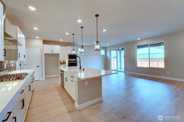 20907 150th St E Unit 1460, Bonney Lake, WA 98391 - kitchen with light wood-style flooring, recessed lighting, stainless steel appliances, a sink, and tasteful backsplash