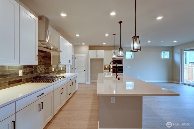 20907 150th St E Unit 1460, Bonney Lake, WA 98391 - kitchen featuring tasteful backsplash, recessed lighting, light wood-style flooring, appliances with stainless steel finishes, and wall chimney range hood